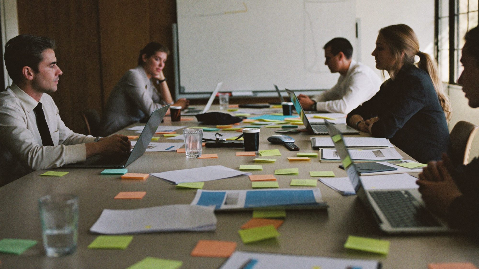 Two people sitting together over notes and a laptop, working out where Ai fits